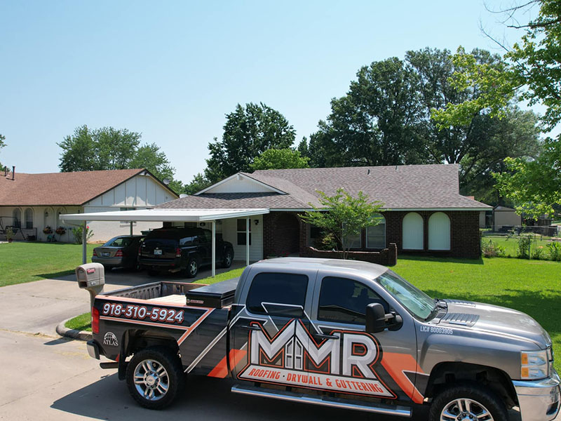 MMR Home Solutions LLC pickup parked in front of a residential home that just had new brown roofing shingles installed by MMR Home Solutions LLC